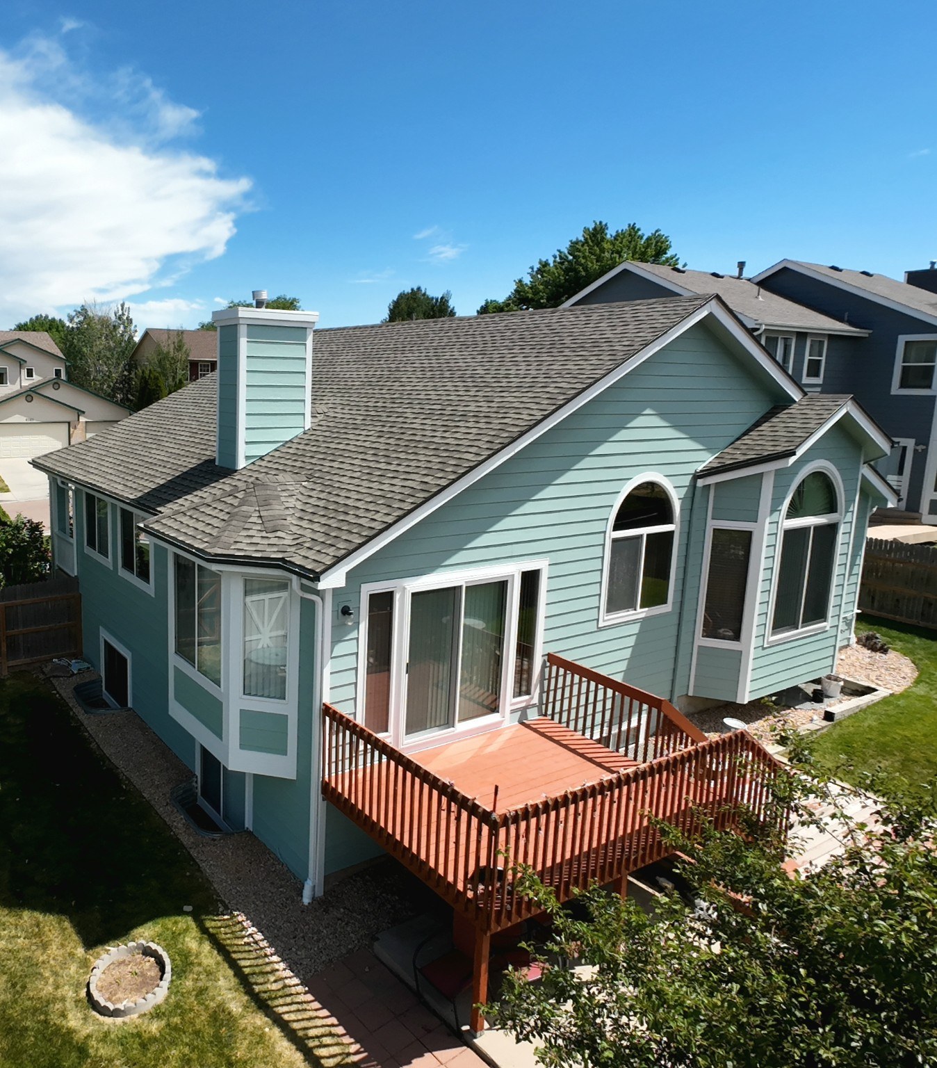 Freshly painted blue-green Colorado home with white trim and backyard deck